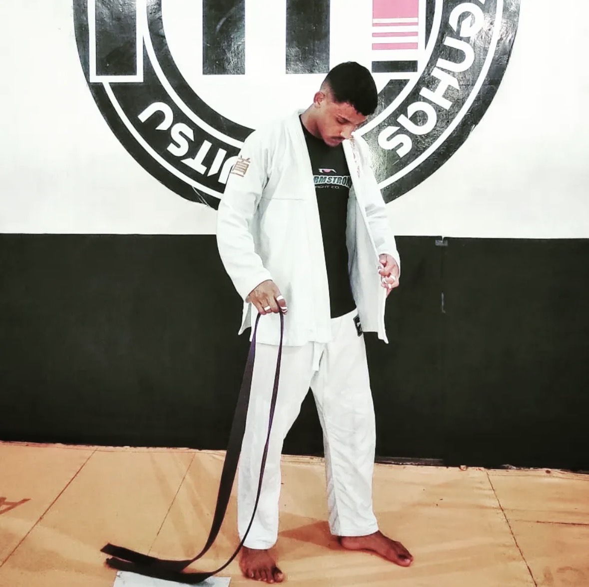 Professor Weverson no tatami a apertar a faixa preta antes da aula de Jiu-Jitsu das 07h00 da EBJJ Portugal