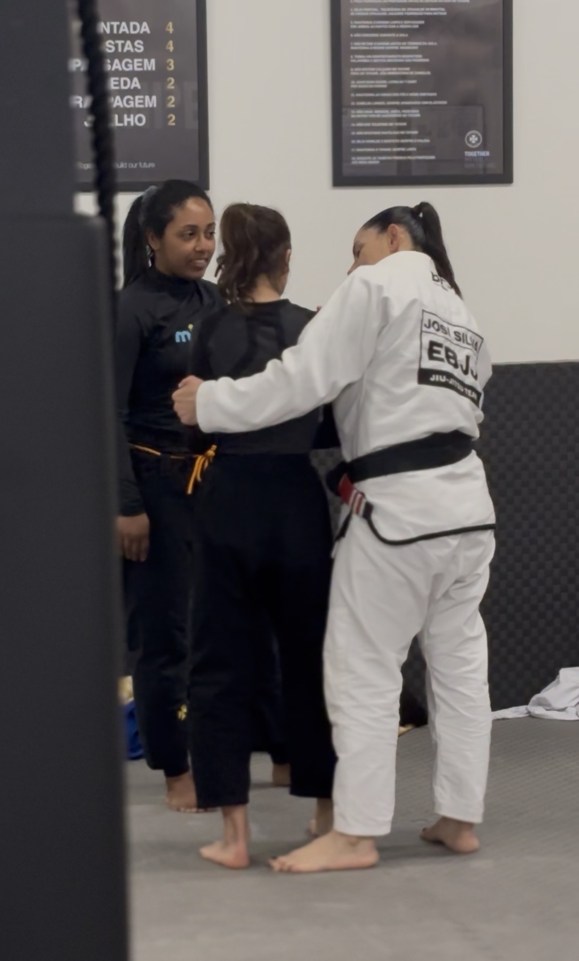 Professora Josiane Silva a corrigir a postura de uma aluna durante um treino de Jiu-Jitsu